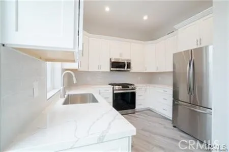 a kitchen with granite countertop a refrigerator stove and sink