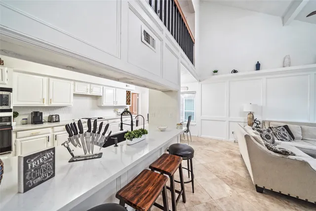 a living room with furniture and a dining table with wooden floor