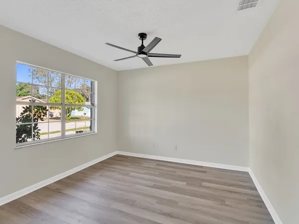 wooden floor in an empty room with a window
