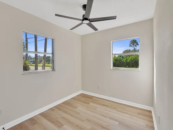 a view of an empty room with a window and a ceiling fan