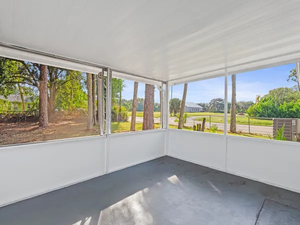an empty room with large windows and city view