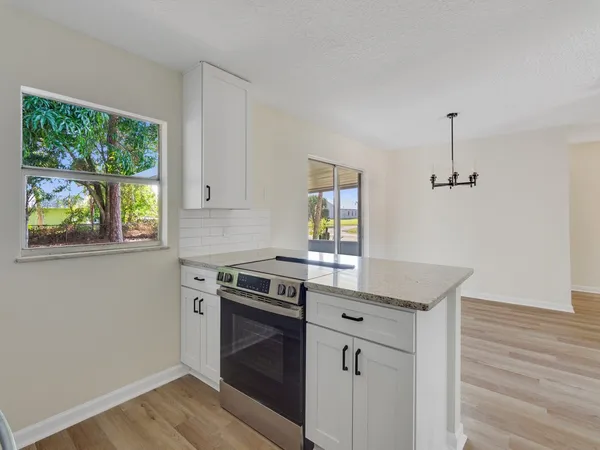 a kitchen with appliances cabinets and a wooden floor