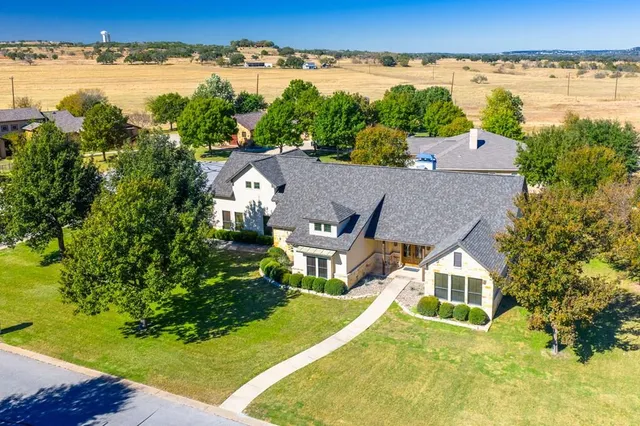 an aerial view of a house with a garden and lake view