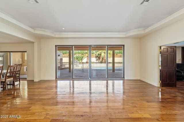 a view of empty room with wooden floor and floor to ceiling window