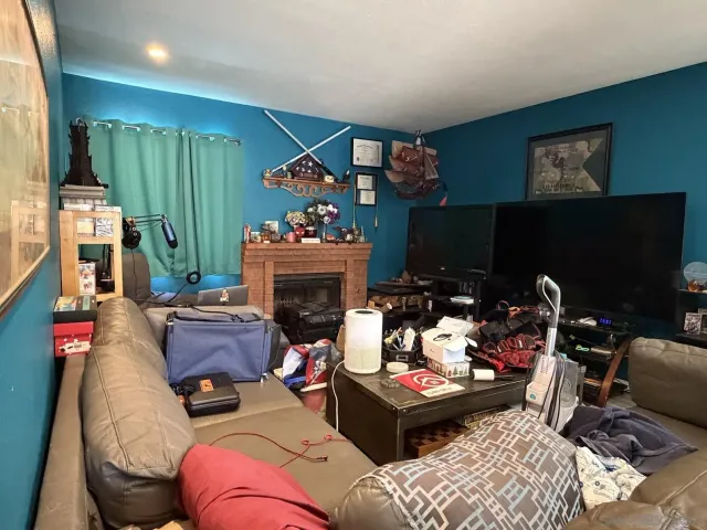 a living room with furniture a fireplace and a flat screen tv