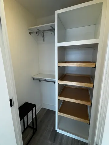 a view of walk in closet with empty racks