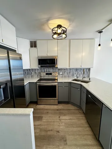 a kitchen with stainless steel appliances granite countertop a stove a sink dishwasher a refrigerator and a microwave