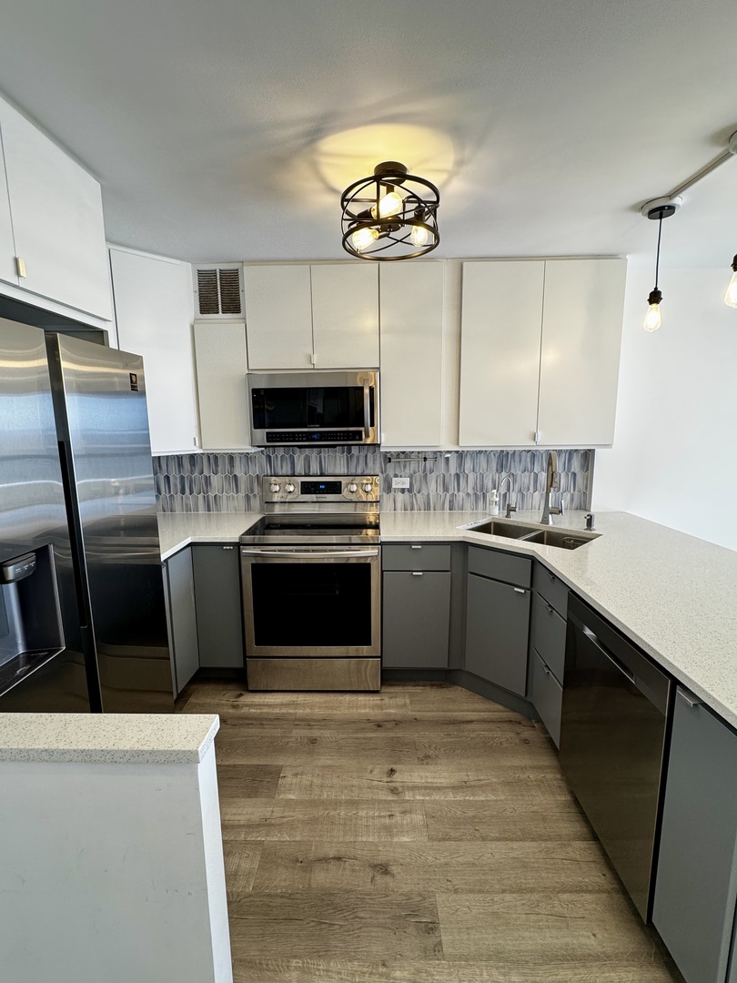 5415 North Sheridan Road, Unit 5414 Chicago, IL 60640 - Photo 9 of 18 a kitchen with stainless steel appliances granite countertop a stove a sink dishwasher a refrigerator and a microwave