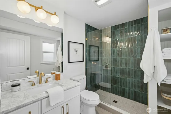 a bathroom with a sink a toilet and shower