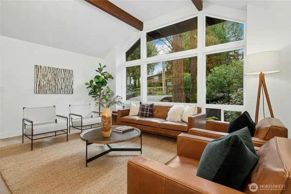 a living room with furniture and floor to ceiling windows