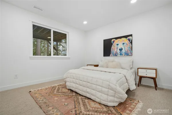 a bedroom with a bed and a painting on the wall