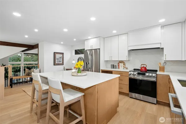 a kitchen with a stove a refrigerator and a dining table with wooden floor