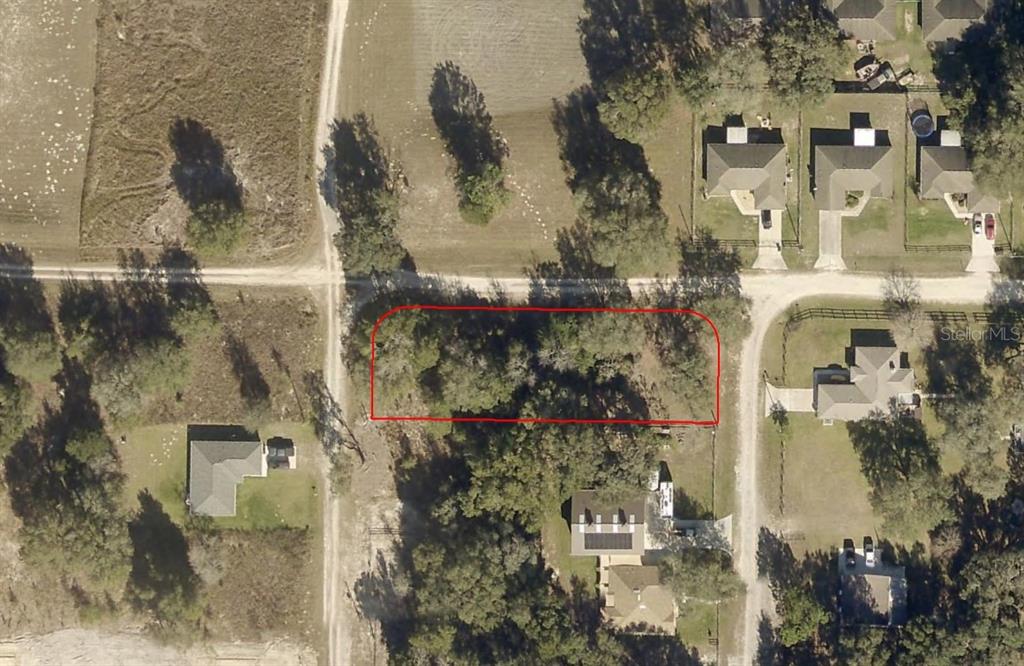 a aerial view of a house with a yard and large trees