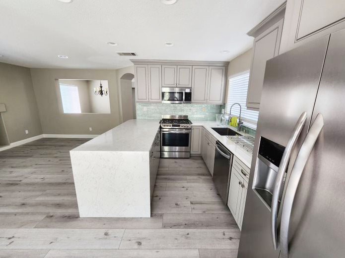 948 Bingham Drive Corona, CA 92882 - Photo 7 of 14 a kitchen with granite countertop a sink a counter top space stainless steel appliances and cabinets