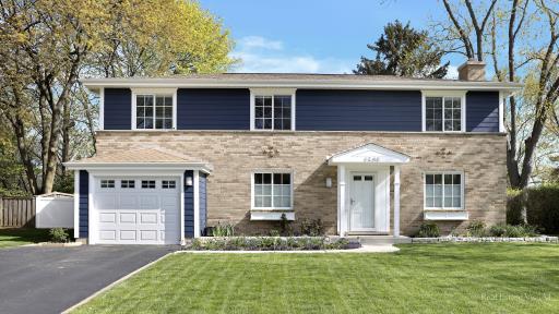 a front view of a house with a yard and trees