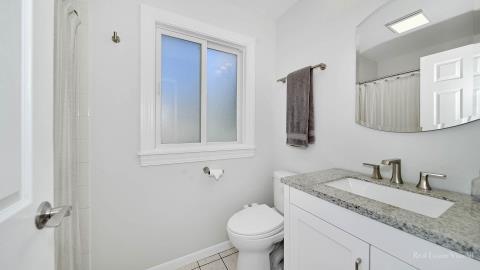 1248 Hackberry Road Deerfield, IL 60015 - Photo 26 of 40 a bathroom with a granite countertop sink toilet and mirror