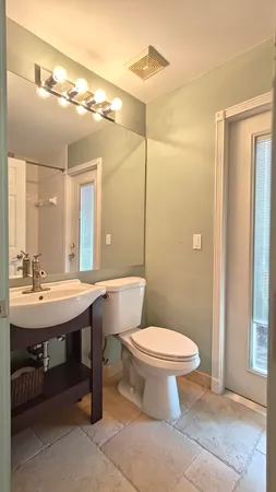 a bathroom with a sink a toilet a mirror and shower