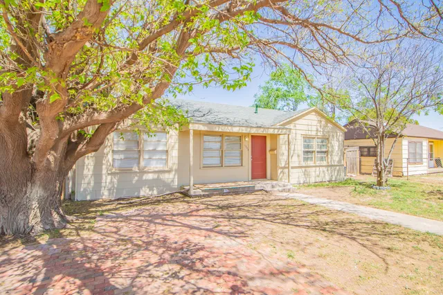 a view of a house with a tree in front