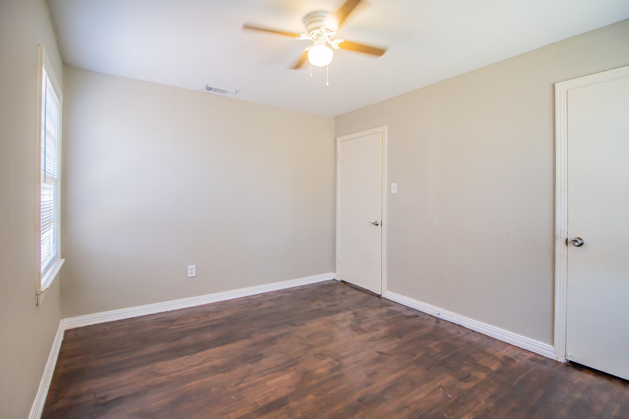 1304 42nd Street Lubbock, TX 79412 - Photo 13 of 17 a view of an empty room with window and wooden floor