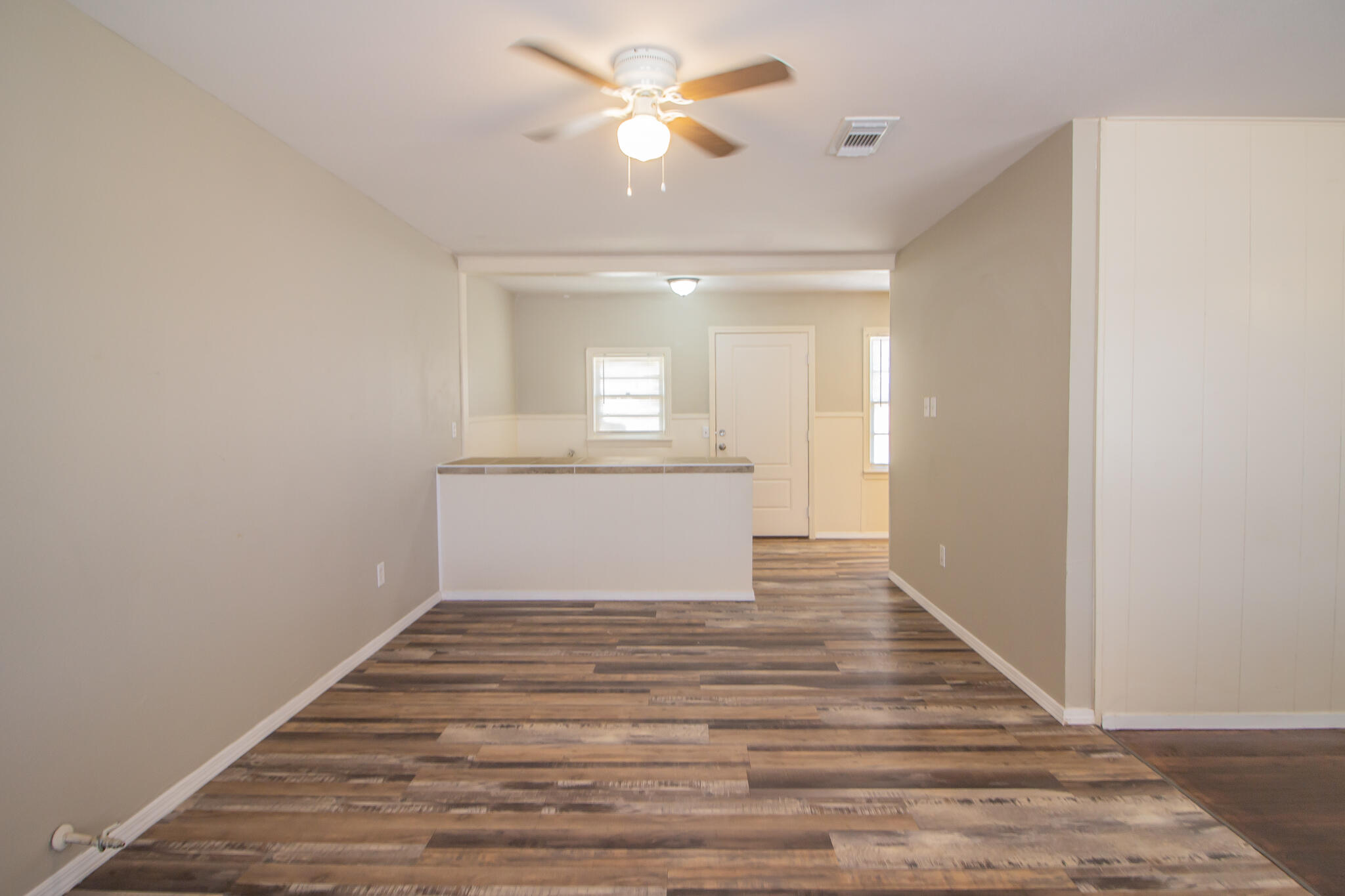 1304 42nd Street Lubbock, TX 79412 - Photo 5 of 17 a view of a room with wooden floor and a ceiling fan
