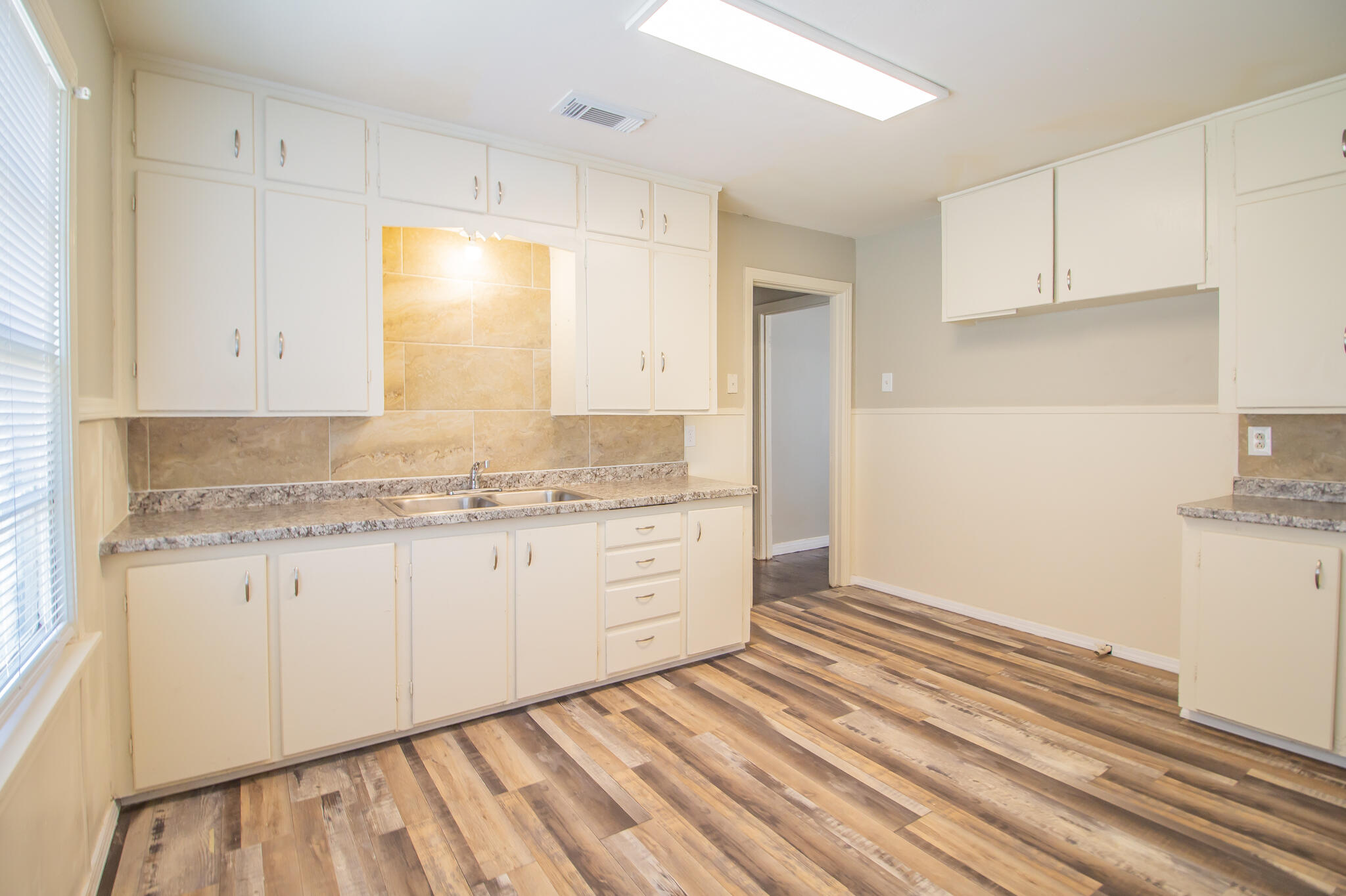 1304 42nd Street Lubbock, TX 79412 - Photo 8 of 17 a bathroom with granite countertop white cabinets and a sink