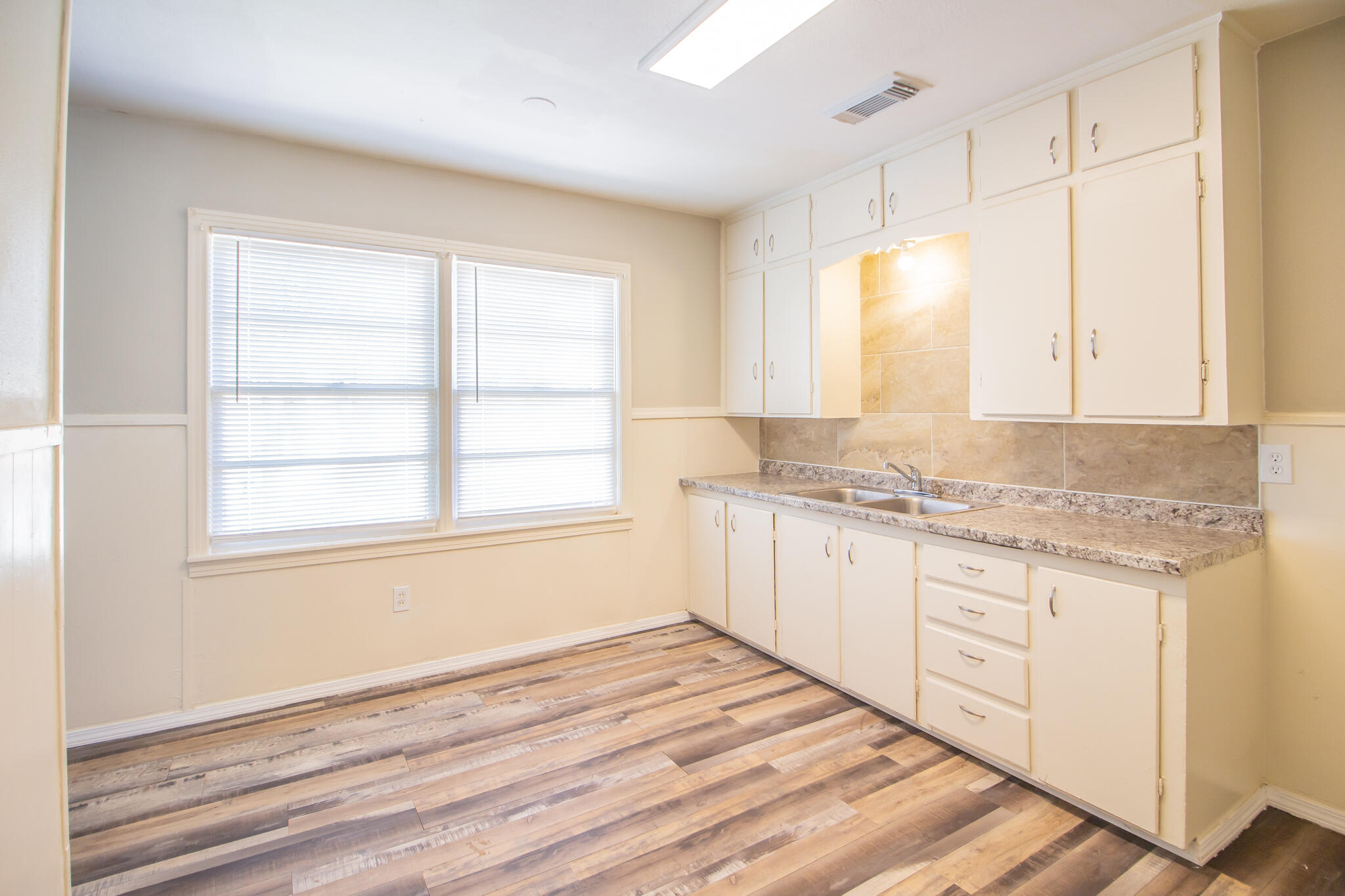 1304 42nd Street Lubbock, TX 79412 - Photo 10 of 17 a bathroom with granite countertop a sink and a window