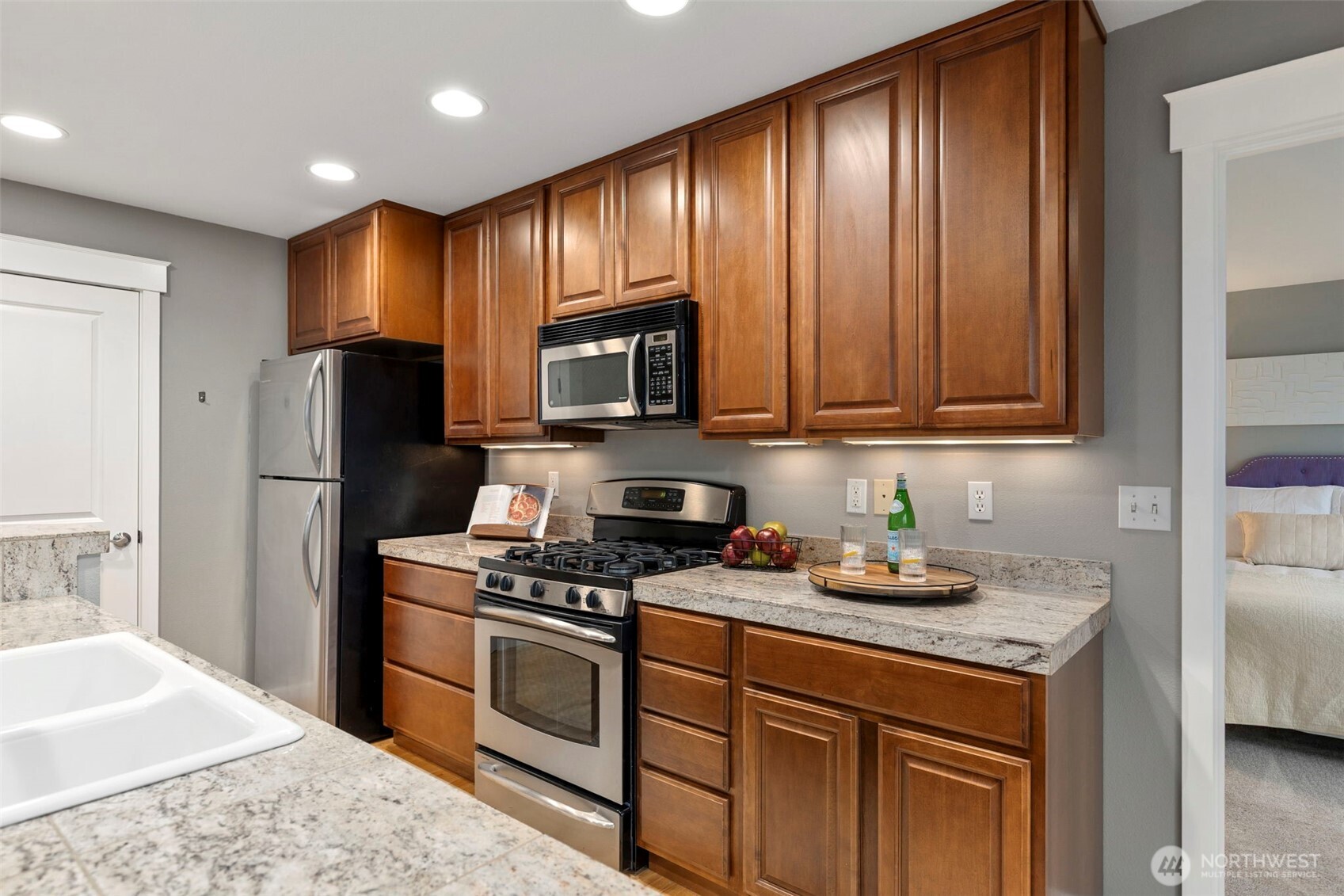 219 Apple Street Bremerton, WA 98310 - Photo 19 of 39 a kitchen with stainless steel appliances granite countertop a stove a refrigerator and a sink with wooden cabinets