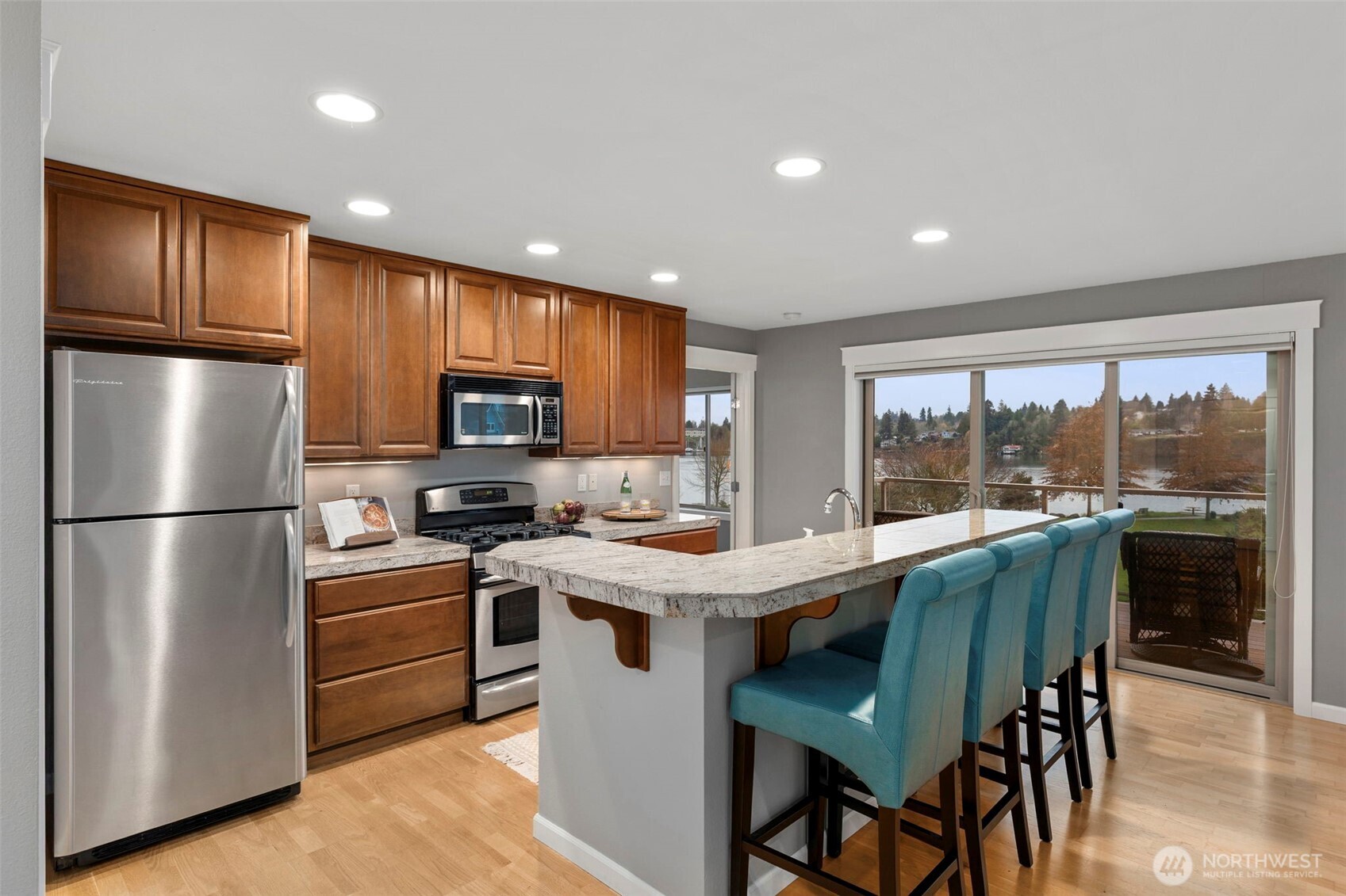 219 Apple Street Bremerton, WA 98310 - Photo 9 of 39 a kitchen with a refrigerator a stove a sink dishwasher with a dining table and chairs