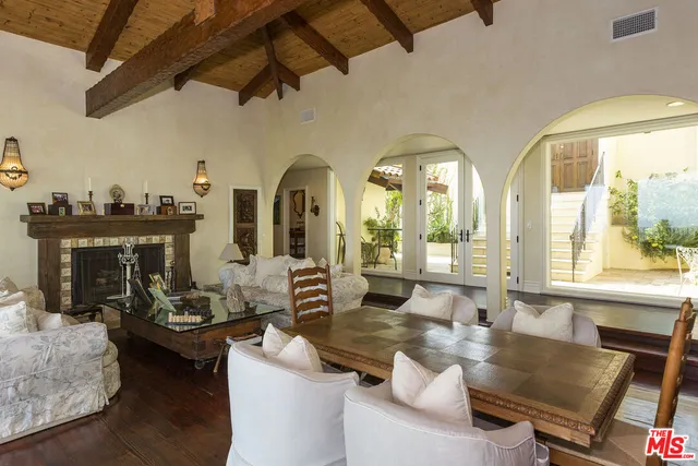 a living room with fireplace furniture and a large window