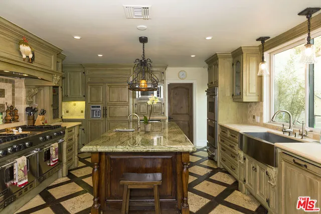 a kitchen with stainless steel appliances granite countertop sink stove and refrigerator