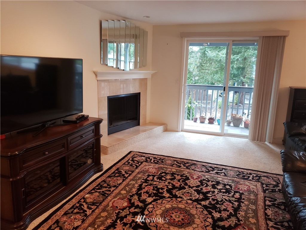 7510 208th Street Southwest, Unit B202 Edmonds, WA 98026 - Photo 3 of 13 a living room with a flat screen tv and a fireplace