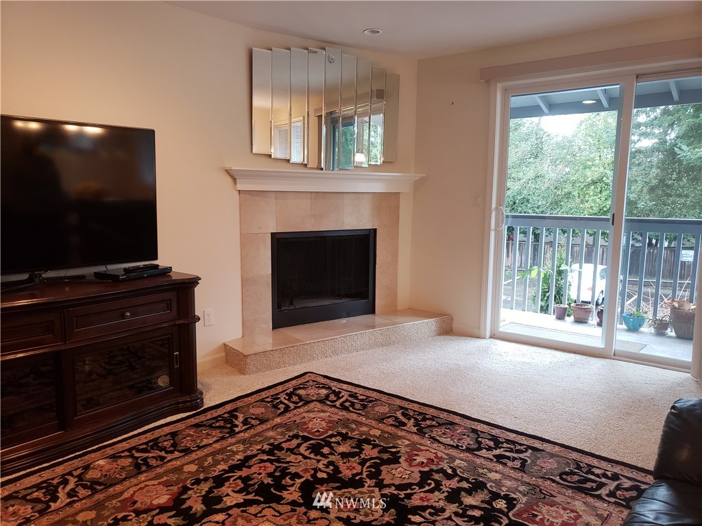 7510 208th Street Southwest, Unit B202 Edmonds, WA 98026 - Photo 4 of 13 a living room with a fireplace and a flat screen tv