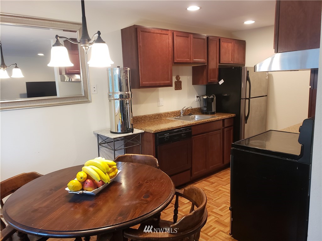 7510 208th Street Southwest, Unit B202 Edmonds, WA 98026 - Photo 5 of 13 a kitchen with stainless steel appliances granite countertop a sink refrigerator and microwave