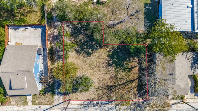 an aerial view of a house with a yard and large trees