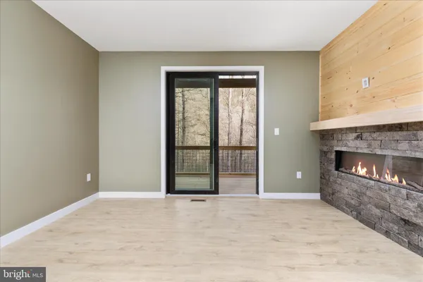 a view of an empty room with a fireplace and a window