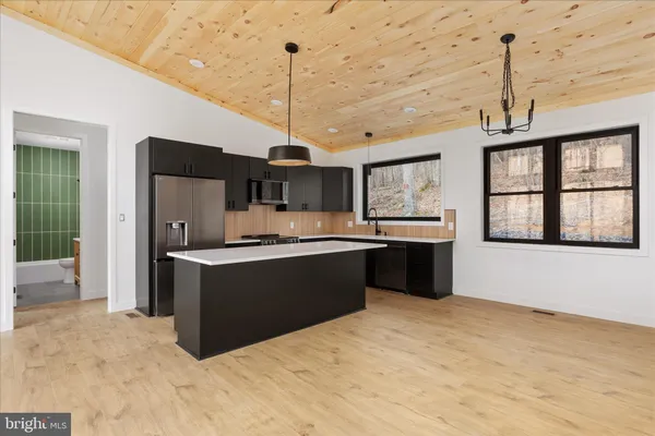 a large kitchen with kitchen island a sink stainless steel appliances and cabinets