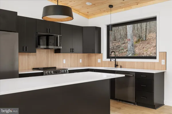 a kitchen with stainless steel appliances a sink a stove and a refrigerator