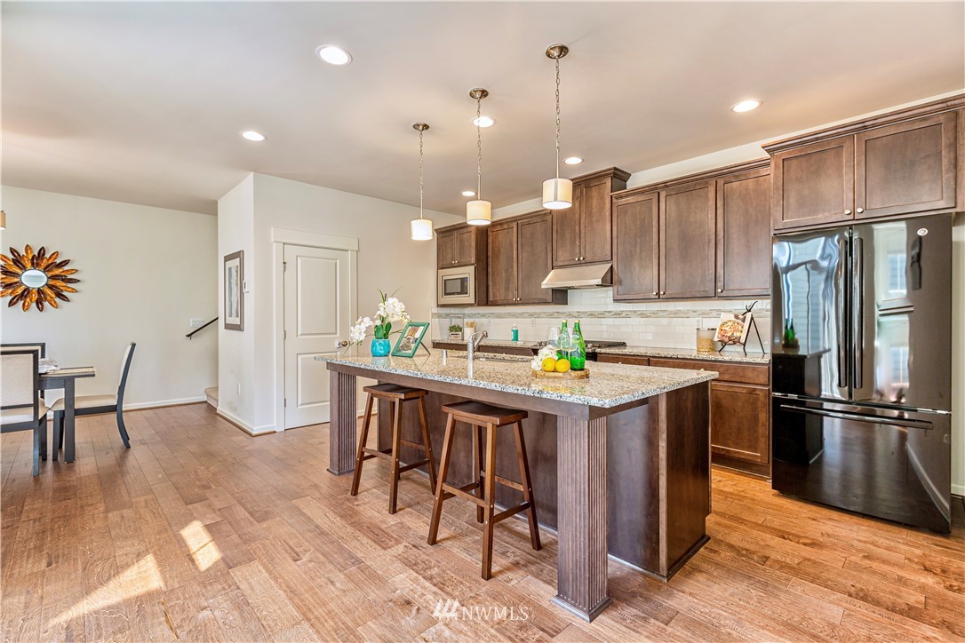 4521 185th Place Southeast Bothell, WA 98012 - Photo 6 of 33 a kitchen with kitchen island a wooden floor and white stainless steel appliances