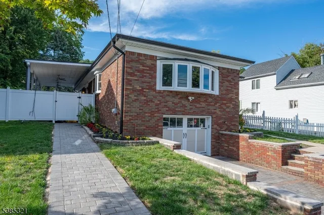 a front view of a house with a yard and lake view
