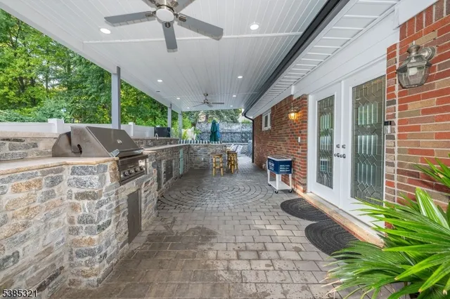 a open kitchen with stainless steel appliances granite countertop a barbecue grill and a dining table