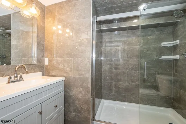 a bathroom with a shower sink and mirror
