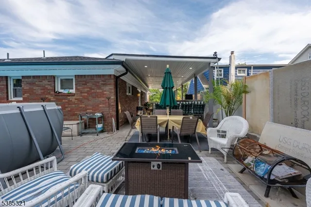 a view of a patio with a dining table and chairs with wooden floor