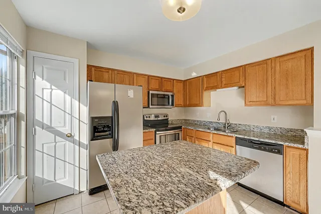 a kitchen with stainless steel appliances granite countertop a sink refrigerator and stove