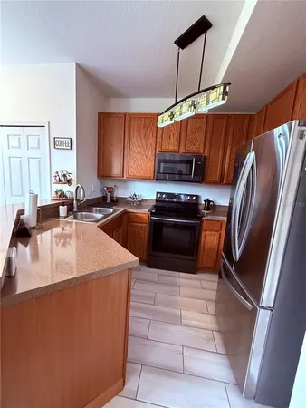 a kitchen with stainless steel appliances granite countertop a sink a stove and a refrigerator