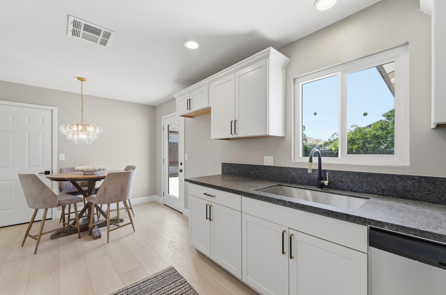 6237 Claus Road Riverbank, CA 95367 - Photo 17 of 53 a kitchen with granite countertop white cabinets and chairs