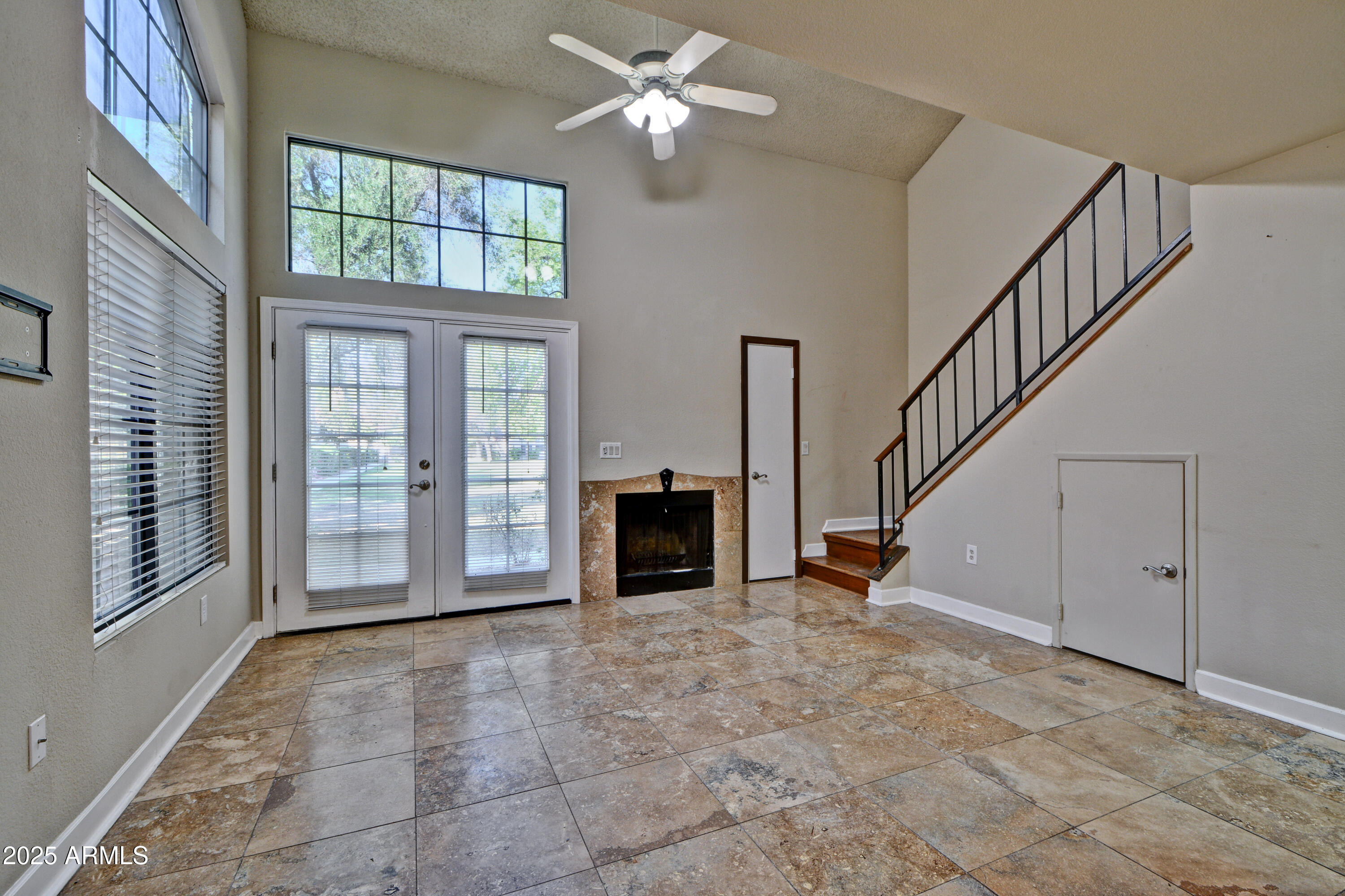 602 North May, Unit 17 Mesa, AZ 85201 - Photo 10 of 39 a view of livingroom with fireplace chandelier fan and windows