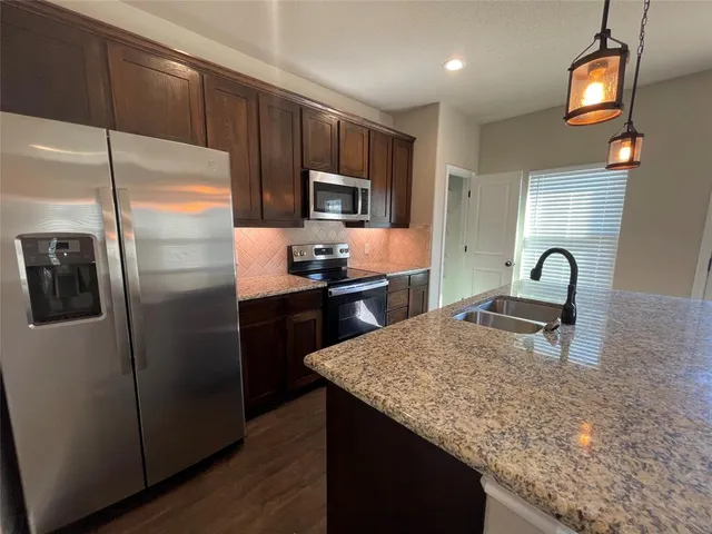 a kitchen with granite countertop stainless steel appliances and wooden cabinets