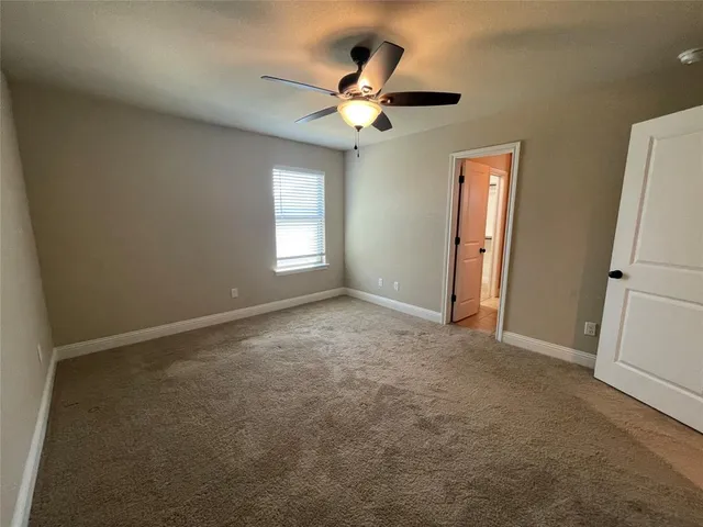 an empty room with closet and a chandelier fan