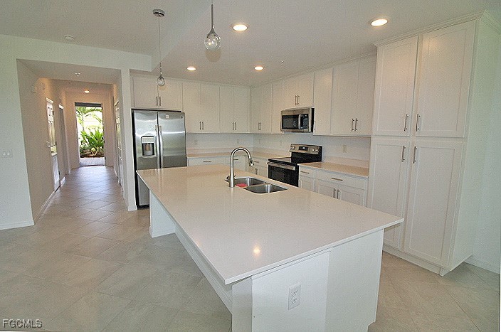 43997 Boardwalk Loop, Unit 1816 Punta Gorda, FL 33982 - Photo 5 of 44 a large kitchen with stainless steel appliances kitchen island granite countertop a refrigerator a sink a stove and white cabinets