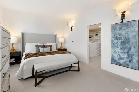 a bedroom with a bed mirror and window